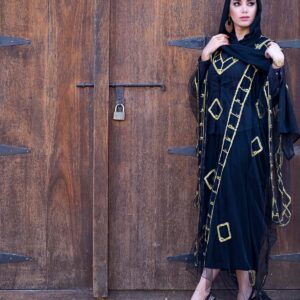 Woman in a black and gold occasion abaya - Noor Beaded Evening Abaya in champagne