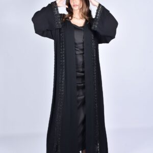 Woman posing in a flowing black abaya - Farah Cape-Sleeve Occasion Abaya in onyx