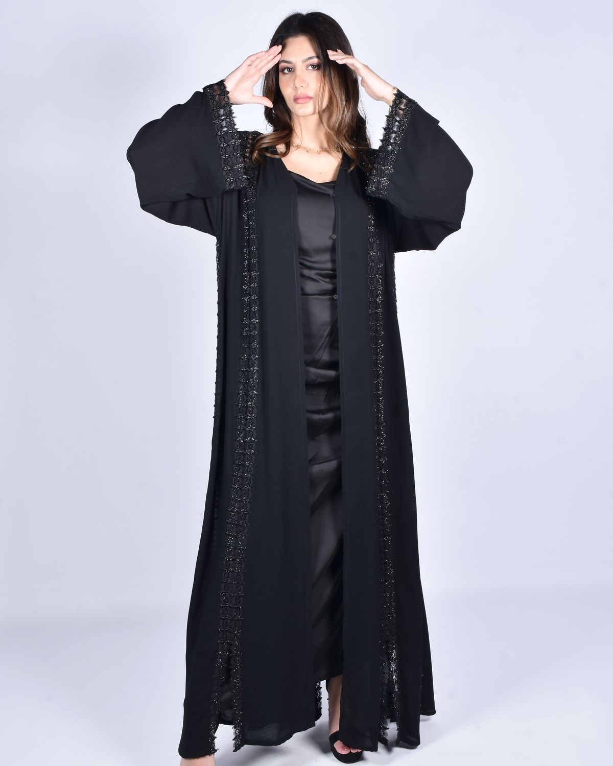 Woman posing in a flowing black abaya - Farah Cape-Sleeve Occasion Abaya in onyx